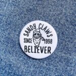 Sandy Claws Badge White